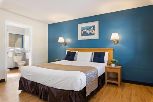 a bedroom with a large bed with a blue wall at Skylark Shores Resort in Lakeport