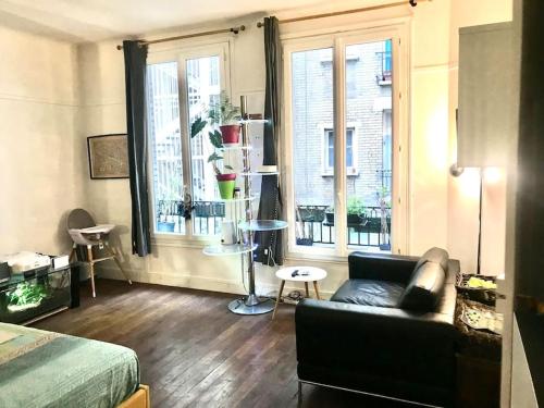 un salon avec un canapé et une grande fenêtre dans l'établissement Appartement Saint Germain, à Paris