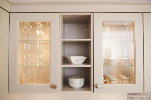 a white cabinet with glass doors with dishes at Doppelzimmer Salzhausen in Westergellersen
