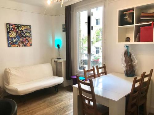 un salon avec une table et des chaises et une fenêtre dans l'établissement Appartement Saint Germain, à Paris
