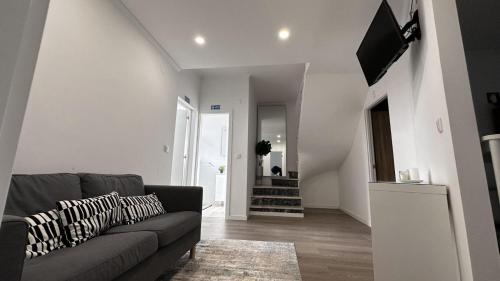a living room with a couch and a tv at DOCE DREAM GUEST HOUSE in Santa Iria da Azóia