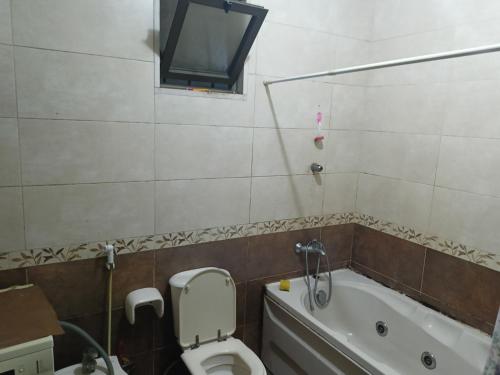 a bathroom with a toilet and a bath tub at الاردن in Ţāb Kirā‘