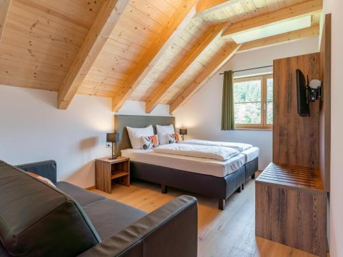 een slaapkamer met een bed en een bank bij Chalet Amsel in Donnersbachwald