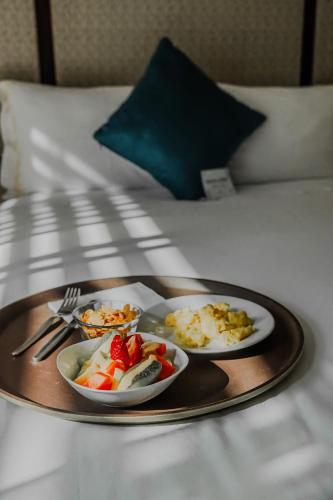 a tray with three plates of food on a bed at Hotel D'Carlo Class in Arequipa