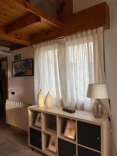 Una habitación con una ventana con jarrones y una lámpara. en Mamá Mila, en Briviesca