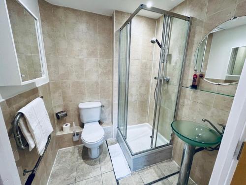 a bathroom with a shower and a toilet and a sink at Exquisite City Centre Apartment - 2 Bed 2 Bath - Free Parking - Netflix Amazon Disney Enabled Smart TV in Birmingham