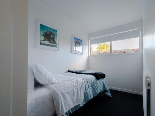 ein weißes Schlafzimmer mit einem Bett und einem Fenster in der Unterkunft Kings Cottage in Cambridge