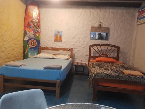 een slaapkamer met 2 bedden en een tafel en een stoel bij Huanchaco Surf Camp in Huanchaco