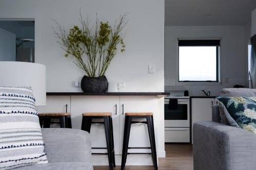 a kitchen with a couch and two stools and a counter at Kings Cottage in Cambridge