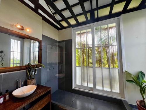 uma casa de banho com um lavatório, um chuveiro e uma janela. em El Resort de Yanashpa - Tarapoto em Tarapoto