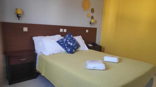 a bedroom with a bed with two towels on it at Hotel Alnacir in Faro