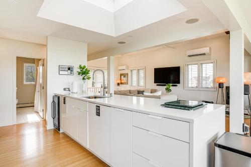 an open kitchen with white cabinets and a large island at Elegant Gloucester Beach Getaway with Ocean Views! in Gloucester