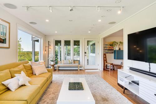a living room with a couch and a tv at Elegant Gloucester Beach Getaway with Ocean Views! in Gloucester
