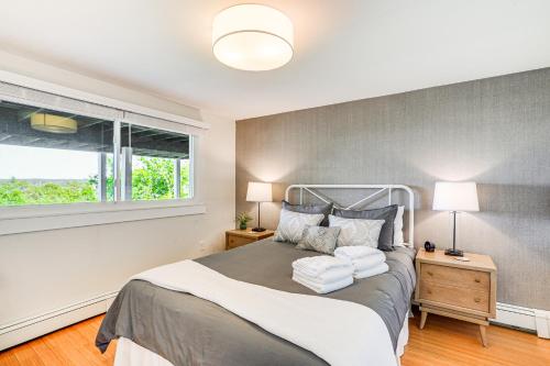 a bedroom with a bed with two lamps and a window at Elegant Gloucester Beach Getaway with Ocean Views! in Gloucester