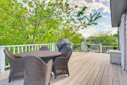 a patio with a table and chairs on a deck at Elegant Gloucester Beach Getaway with Ocean Views! in Gloucester