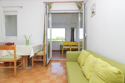 a living room with a green couch and a table at Apartments and rooms with parking space Nin, Zadar - 5805 in Nin
