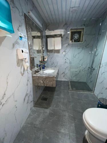 y baño con lavabo, ducha y aseo. en ALSEEB VIEW Serviced Hotel Suites, en Raʼs al Khafjī