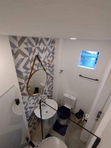a bathroom with a toilet and a mirror at Studio no coração de Petrópolis in Petrópolis