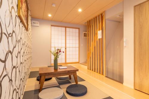 a hallway with a table and a vase of flowers at 金柑小屋 in Osaka