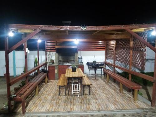 um deque com bancos, uma mesa e um fogão em Cabaña florencia em Coquimbo