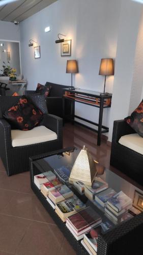 a living room with two couches and a table with books at Hotel Alnacir in Faro