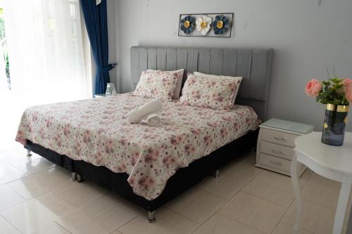 a bedroom with a large bed with pink flowers at Hotel Rosalinda Campestre del Llano in Villavicencio