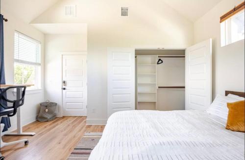 a bedroom with a white bed and a closet at Designer NEW 10min dt Pet friendly 7min Park-Room A in Austin