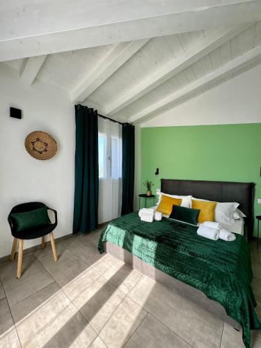 a green bedroom with a bed and a chair at Citroom - green city rooms in Olbia