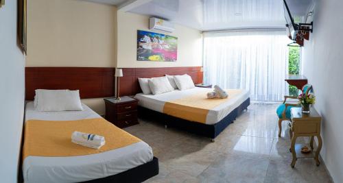 a hotel room with two beds and a window at Hotel Rosalinda Campestre del Llano in Villavicencio