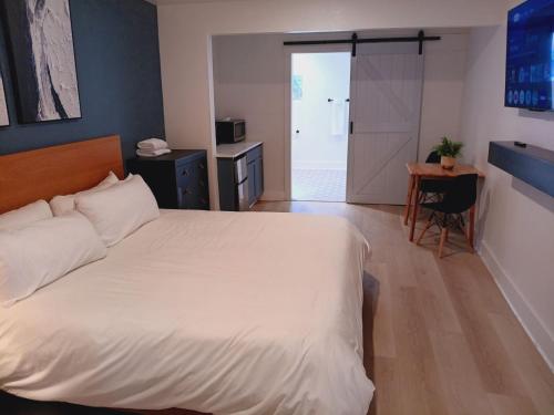 a bedroom with a bed and a table and a door at Five10 Orange Street Hotel - Hot Springs in Hot Springs