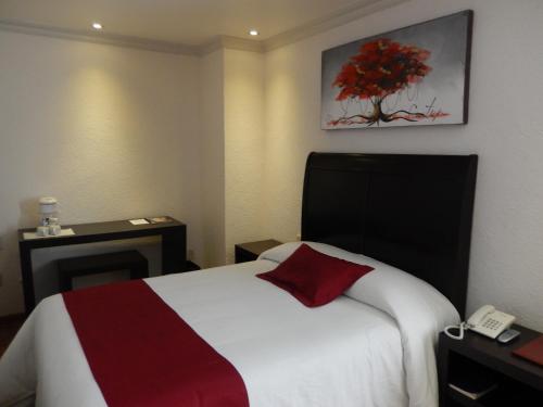 a hotel room with a bed and a telephone at Roma Guadalajara in downtown in Guadalajara