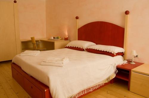レーリチにあるLa Tata B&Bのベッドルーム1室(大型ベッド1台、木製ヘッドボード付)