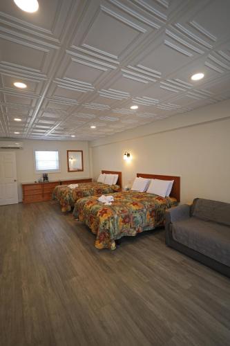 a hotel room with two beds and a couch at Compass Family Resort in Wildwood Crest