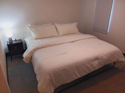 a bed with white sheets and pillows in a room at Five10 Orange Street Hotel - Hot Springs in Hot Springs