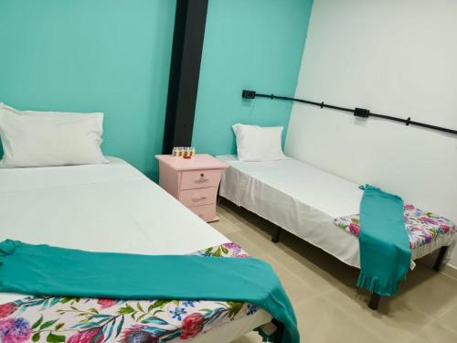 カリにあるCasa Mangoのベッド2台、ナイトスタンド(ベッドスカート付)が備わる客室です。