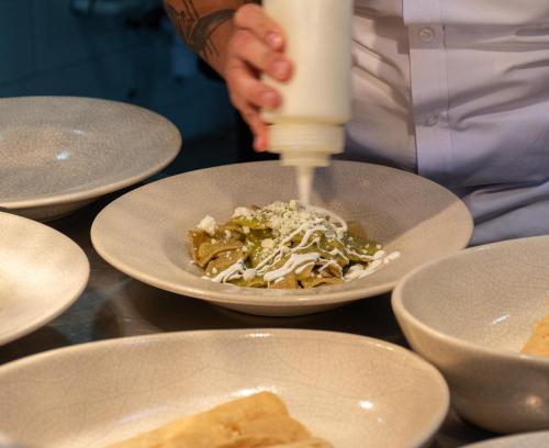 a chef is preparing a plate of food on a table at Casa 1810 Hotel Boutique in San Miguel de Allende