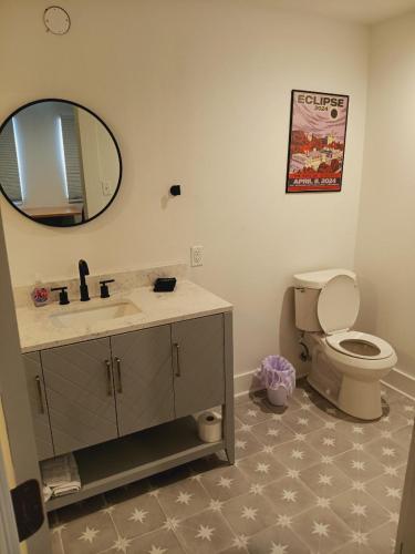a bathroom with a sink and a toilet and a mirror at Five10 Orange Street Hotel - Hot Springs in Hot Springs