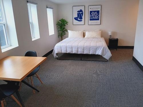a bedroom with a bed and a table and chairs at Five10 Orange Street Hotel - Hot Springs in Hot Springs