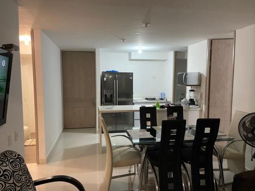 a kitchen with a table with chairs and a refrigerator at peña azul la morada Sánchez in Ricaurte