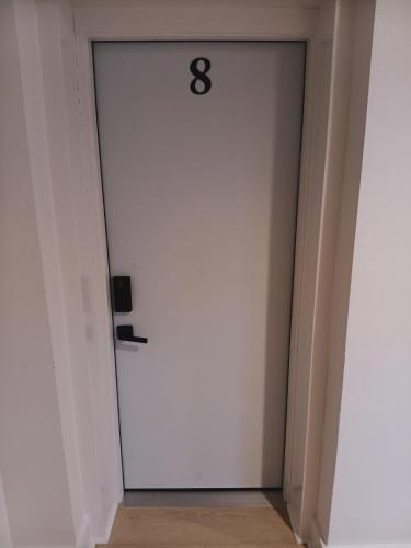 a white door with the number eight on it at Five10 Orange Street Hotel - Hot Springs in Hot Springs