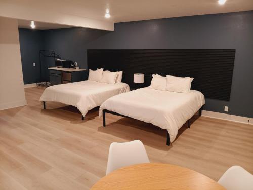 a room with two beds and a table and chairs at Five10 Orange Street Hotel - Hot Springs in Hot Springs