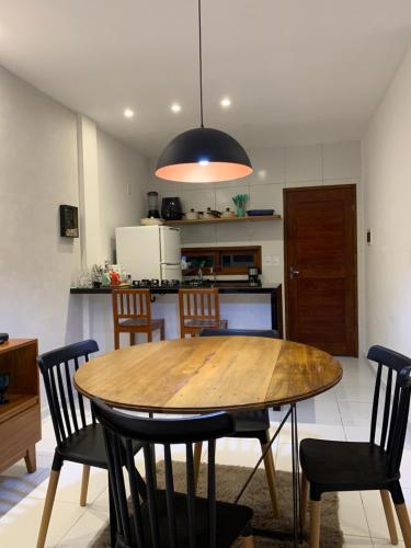 ein Esszimmer mit einem Holztisch und Stühlen in der Unterkunft Blue House Casa de temporada no brejo in Solânea