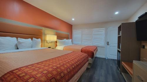 a hotel room with two beds and a television at Presidio Parkway Inn in San Francisco