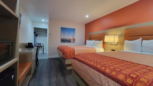 a hotel room with two beds and a flat screen tv at Presidio Parkway Inn in San Francisco