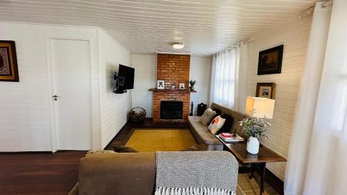 uma sala de estar com um sofá e uma lareira em Casa Blanca Campos do Jordão em Campos do Jordão
