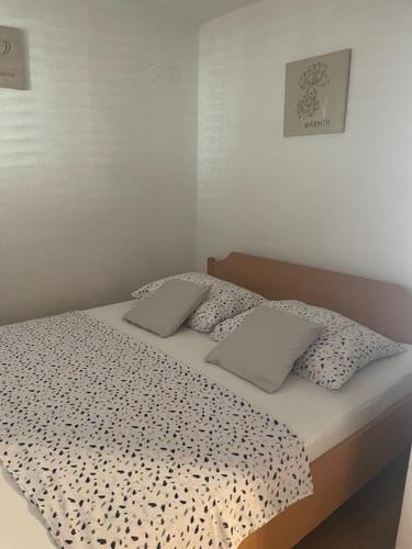 a bed with a black and white comforter and two pillows at Apartments with parking space Sutivan, Brac - 5654 in Sutivan