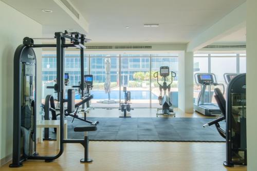a gym with cardio equipment and a swimming pool at Saadiyat Serene Studio in Abu Dhabi