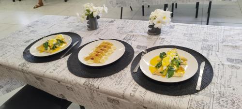 tres platos de comida sentados en una mesa en Toafa Lodge, en ‘Ohonua