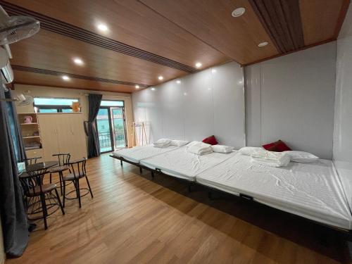 1 dormitorio con 1 cama grande, mesa y sillas en Mộc Homestay, en Mộc Châu