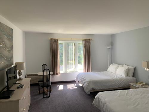 Saint Come的住宿－Hôtel Saint-Côme，酒店客房设有两张床和窗户。